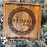 Laser engraved Polynesian tattoo circle design on a wooden cutting board.